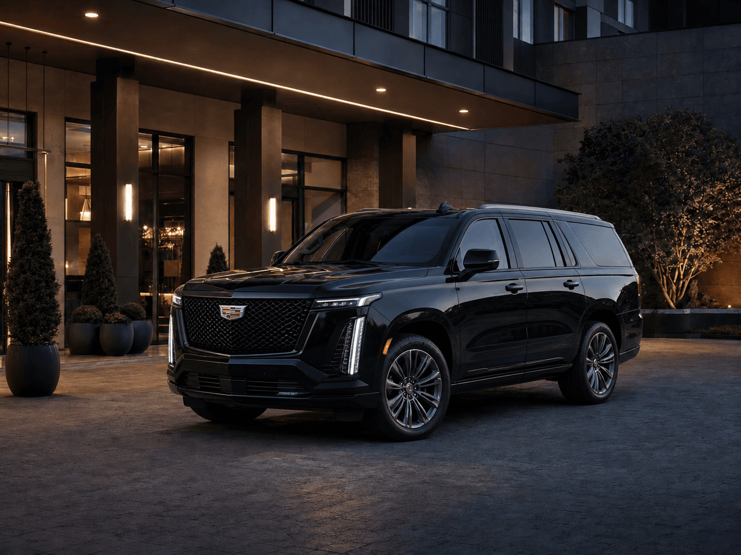 Current-generation black Cadillac Escalade parked outside a premium hotel